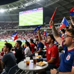 Cakhiatv fans enjoying a live football match with vibrant energy, snacks, and jerseys in an enthusiastic atmosphere.