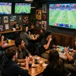 Engaged enthusiasts placing live bets in a buzzing sports bar showcasing 7m betting strategies.
